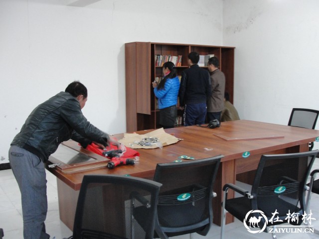 神木市邮政分公司工作人员正在安装书架和摆放图书