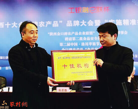 陕西农村报副社长吴武刚（左）接受中国电子商务协会授予“金口碑商城”为“十佳机构”。