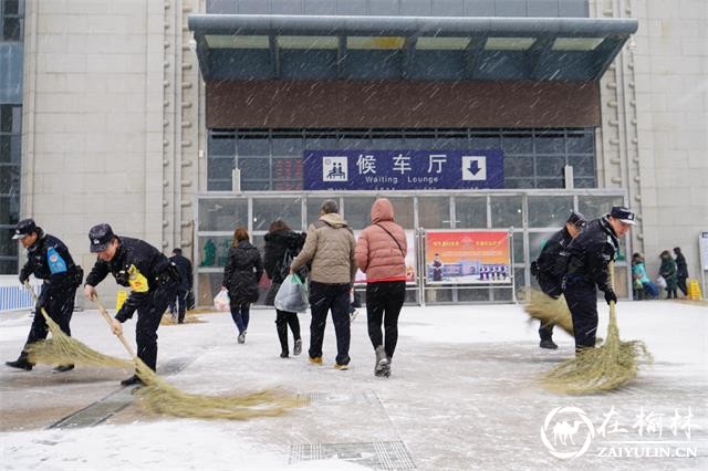 1月27日，革命圣地延安飘起中雪，铁路民警在延安火车站进站口扫雪，避免旅客滑倒。（党浩博/摄）