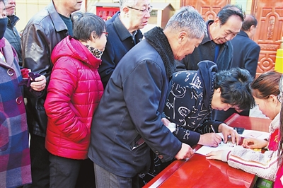 图为老人们在登记领取黄手环
