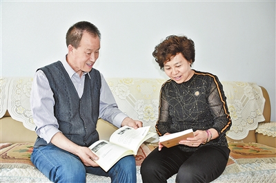 温亚洲（左）和妻子贺俊花在交流读书体会