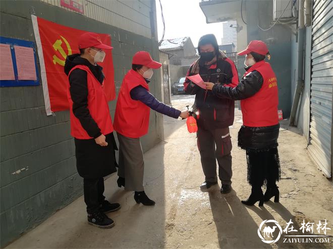 社区党员志愿者在小区宣传、为进出人员消毒