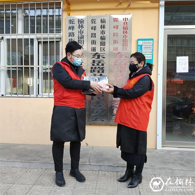 志愿者韩宇鹏将口罩及1000元现金交到社区书记手上