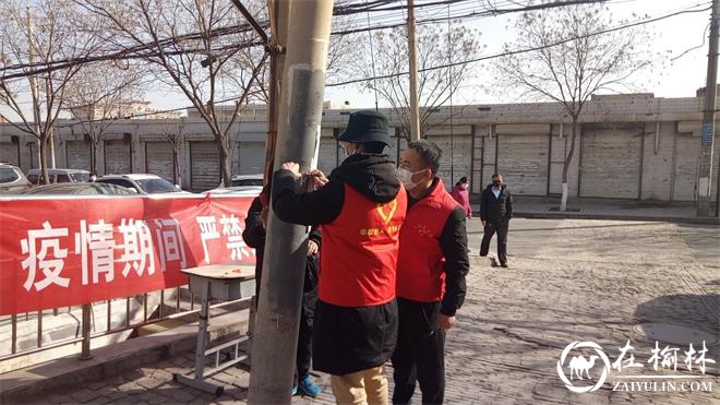 志愿者在巷口张贴宣传单