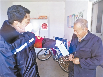 贾和平（左）向村民发放口罩