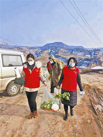 李琼（右）为孤寡老人送蔬菜。（资料照片）