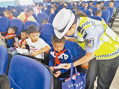 图为民警向小学生讲解交通安全知识。
