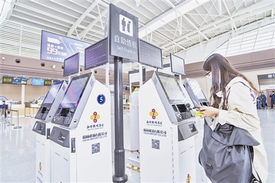旅客在自助值机柜台前打印机票