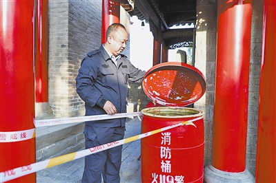 张涛峰在检查景区的消防桶。陈静仁 摄