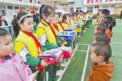 图为榆林高新第一小学学生向管家咀小学学生赠送学习用品。 雷艳艳 摄