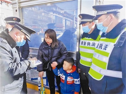 图为城管队员将孩子送到家长手中。马蕊 摄