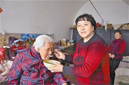 薛振艳（右）给婆婆喂饭。通讯员 董兴利 摄