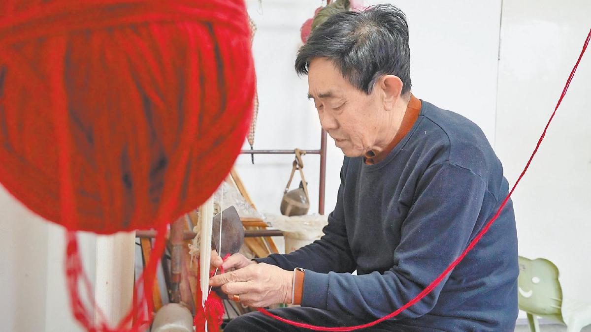 张玉恩正在编织手工地毯。记者王重阳摄
