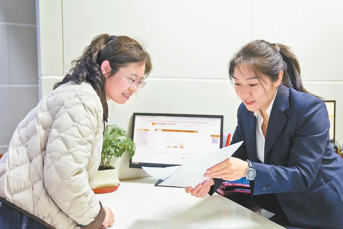 在吴堡县政务服务中心“一件事一次办”窗口，工作人员（右）为办事群众提供企业登记注册“帮代办”服务（三月十六日摄）。通讯员张荩文摄