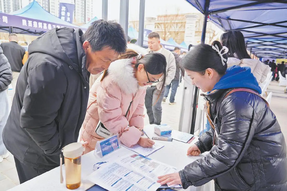 求职者在招聘展位前咨询相关情况。姬静摄