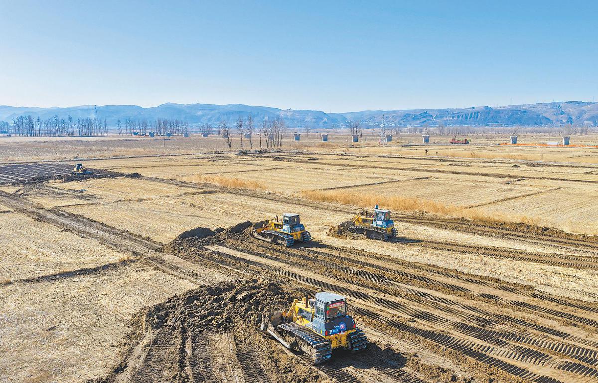 3月19日，榆阳区鱼河镇的农户在开展土地平整作业，备战春耕。