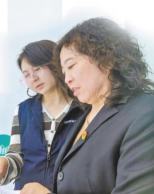 曹林霞（右）和同事商讨调解方案。王婷摄