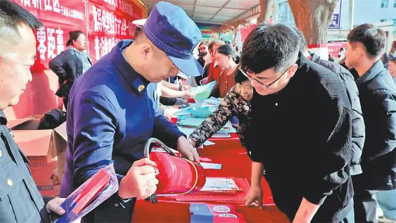 消防救援人员指导居民正确使用灭火器。高书涵摄