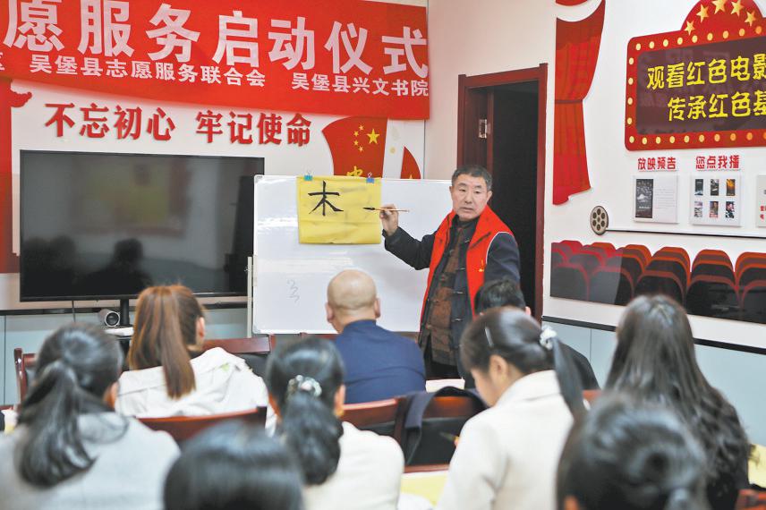 图为志愿者向社区居民讲解书法运笔技巧。张震宇摄