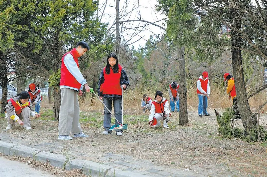 志愿者们清理绿化带内积存的生活垃圾和废弃杂物。张瑜摄