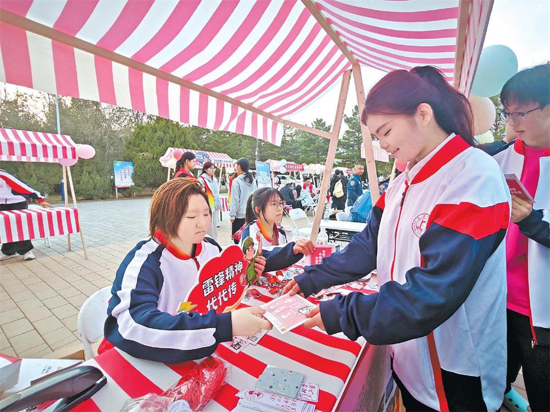 榆林大学的学生们正在领取学雷锋志愿卡。韩飞摄