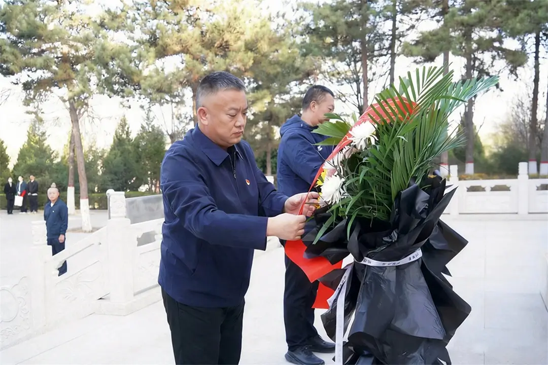 街道党工委书记高峰、榆阳区退役军人事务局副局长张冰共同为革命烈士纪念碑敬献花篮，整理花篮缎带。