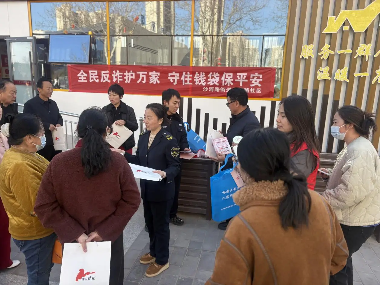 榆阳区沙河路街道桃李路社区在高新二小东路队解散点开展“全民反诈护万家，守住钱袋保平安”反诈宣传活动