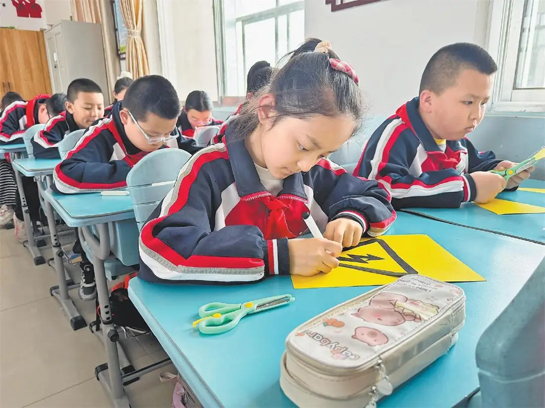 学生剪裁安全标识。陈子涵摄