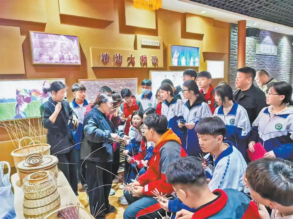 图为学生在传承人的指导下学习柳编基础技法。通讯员黄金梅摄