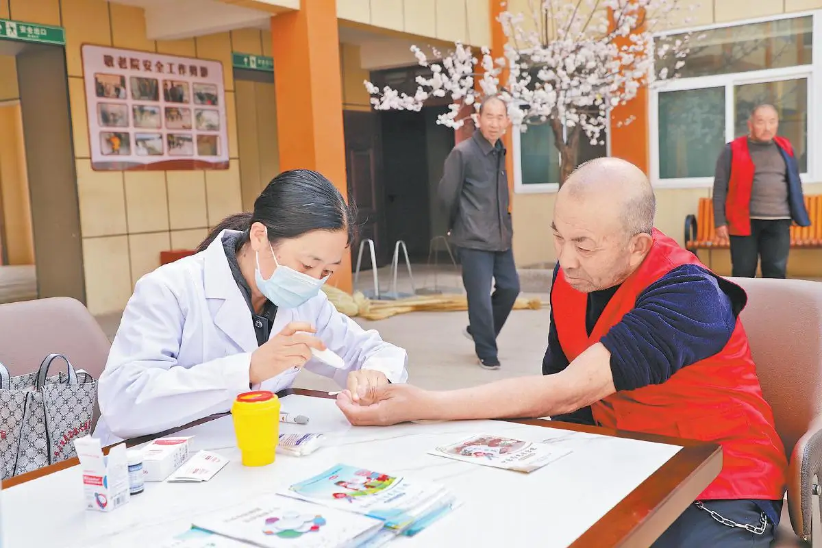 图为志愿者为老人测量血糖。通讯员王雪洁摄