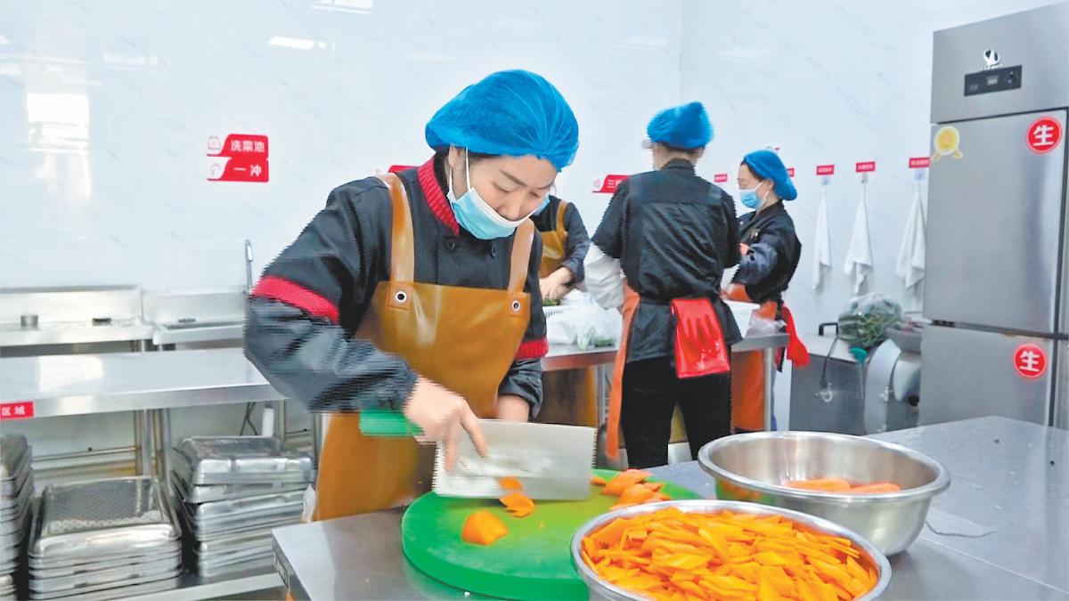 清涧县第六小学帮厨家长在备菜。刘婕宇摄