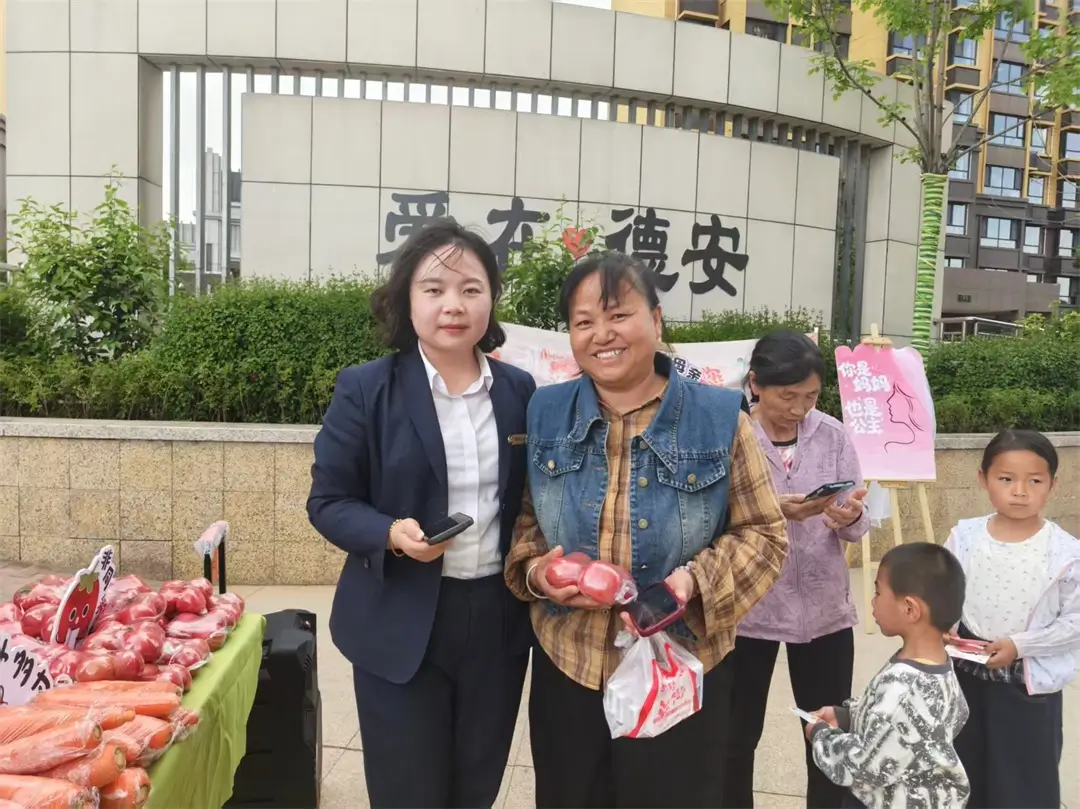 活动现场工作人员为居民兑换蔬