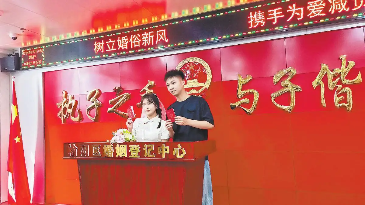 五月二十日，一对新人在榆阳区婚姻登记中心拍照留念。刘香摄