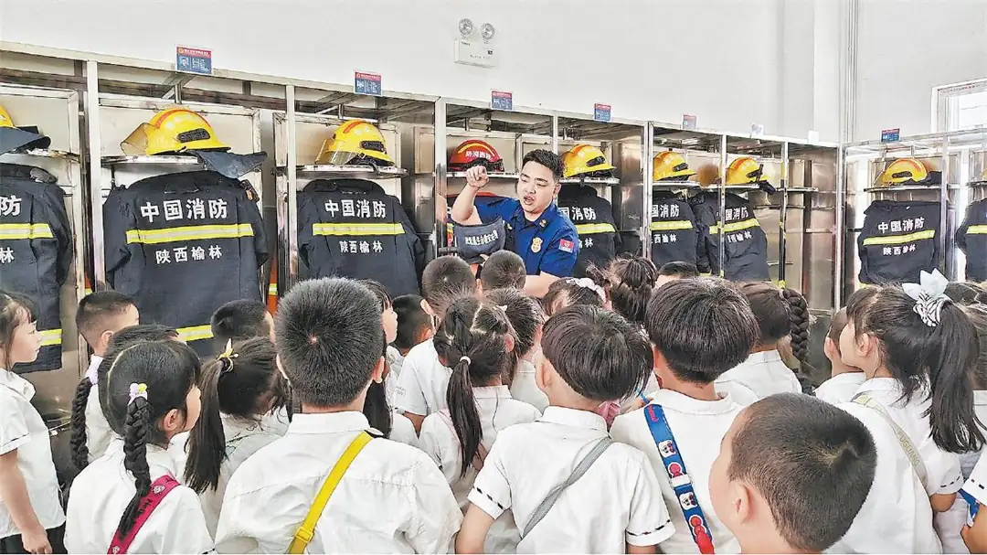 图为消防员向孩子们介绍消防器材的功能和使用方法。张丹摄