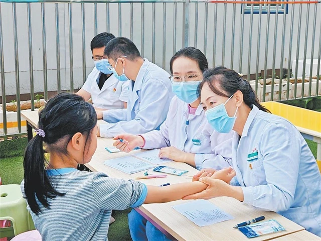 孙香(右一)给小学生义诊。郝彦丰摄