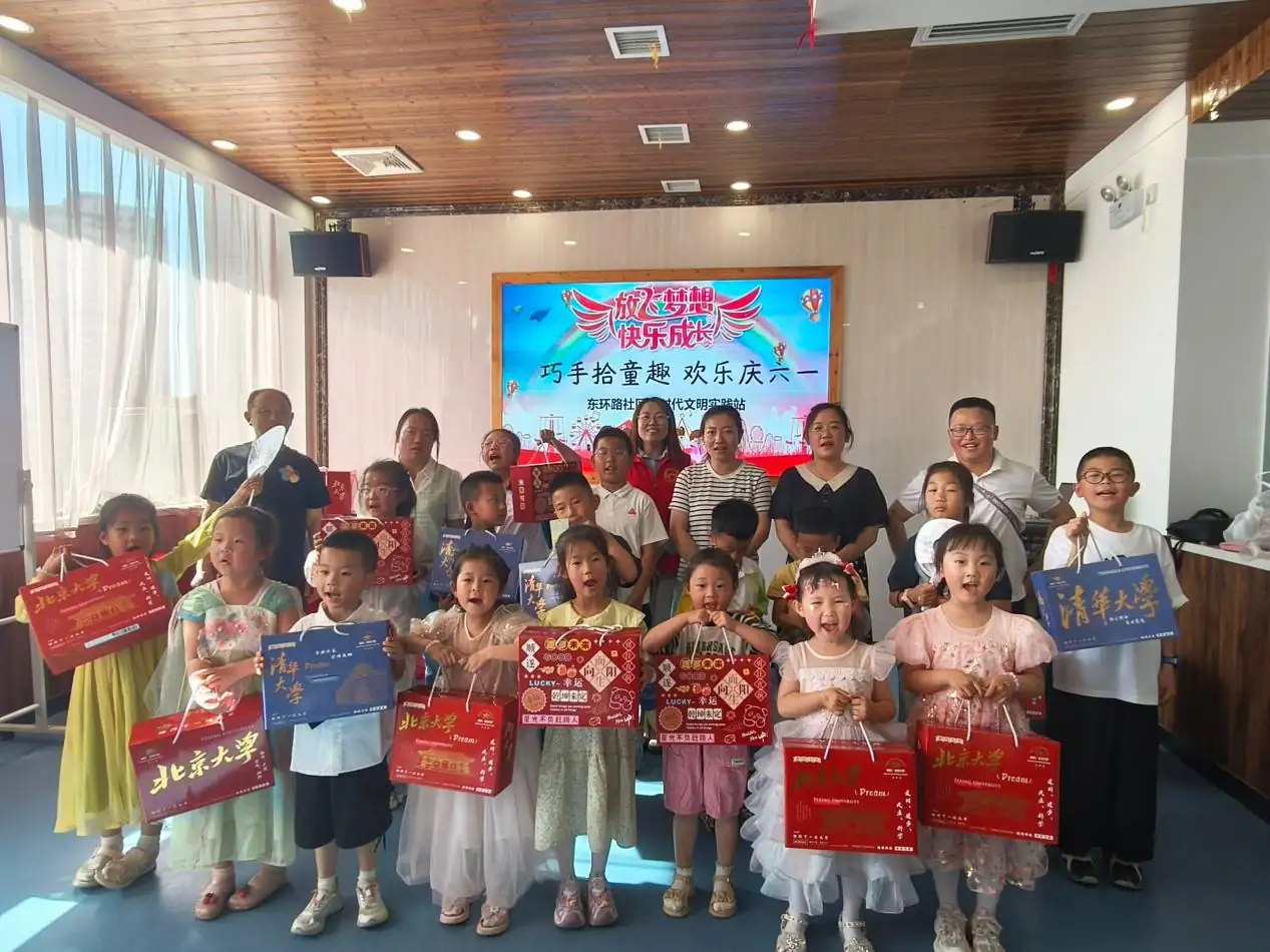 孩子们手捧自己的作品和节日礼品，与志愿者、家长们合影留念。