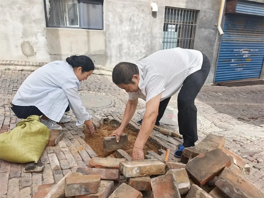 近日,榆阳区崇文路街道葡萄园社区昌兴巷一处路面塌陷,热心居民郭大爷发现后,自掏材料、自带工具,主动将坑洼填平夯实,消除老人孩童出行隐患。