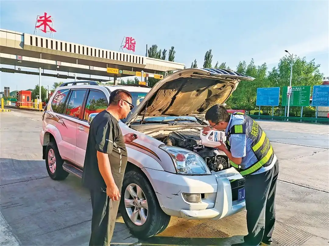 帮司乘人员给车辆水箱加水降温。