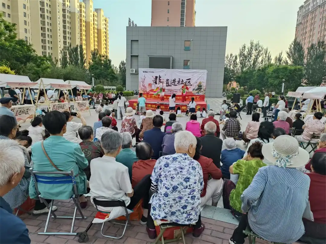 8月9日，榆阳区金沙路街道金榆社区开展“非遗进社区”惠民活动，以二人台、民俗小品等文艺汇演搭配非遗市集，并开设剪纸体验课堂，居民老少同乐巧手创作。
