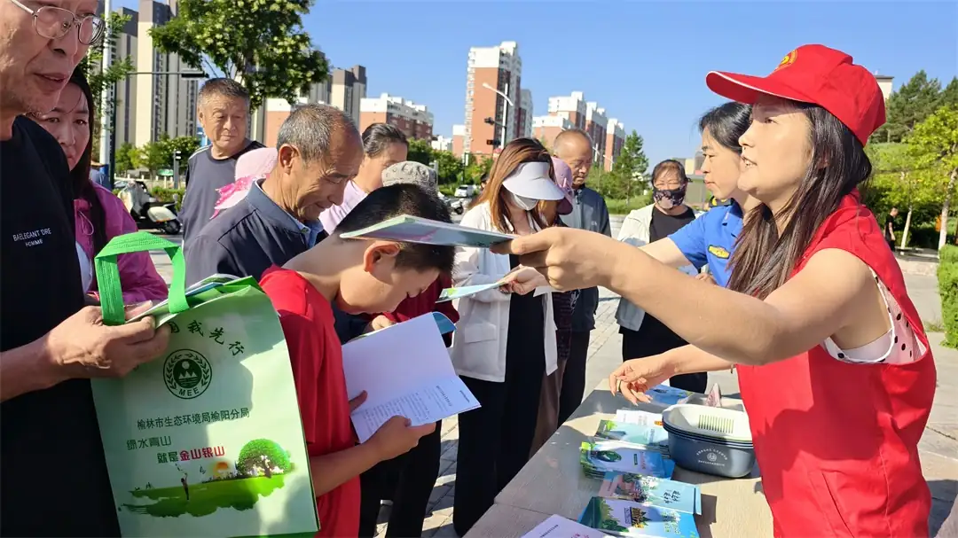 志愿者向居民发放环保宣传手册，现场宣讲生态环保知识